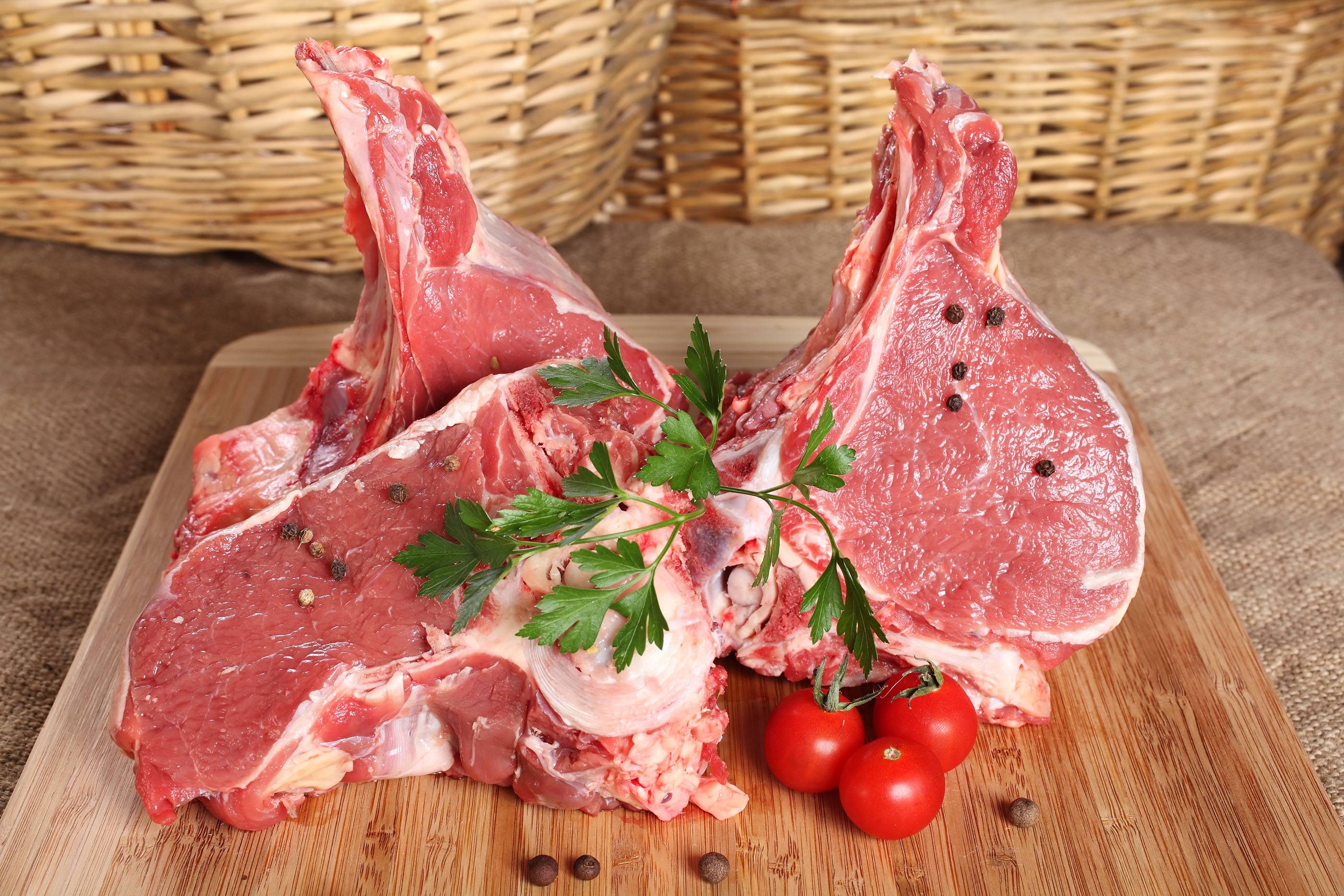 Свежее сырое мясо, говяжий стейк на кости на деревянной доске