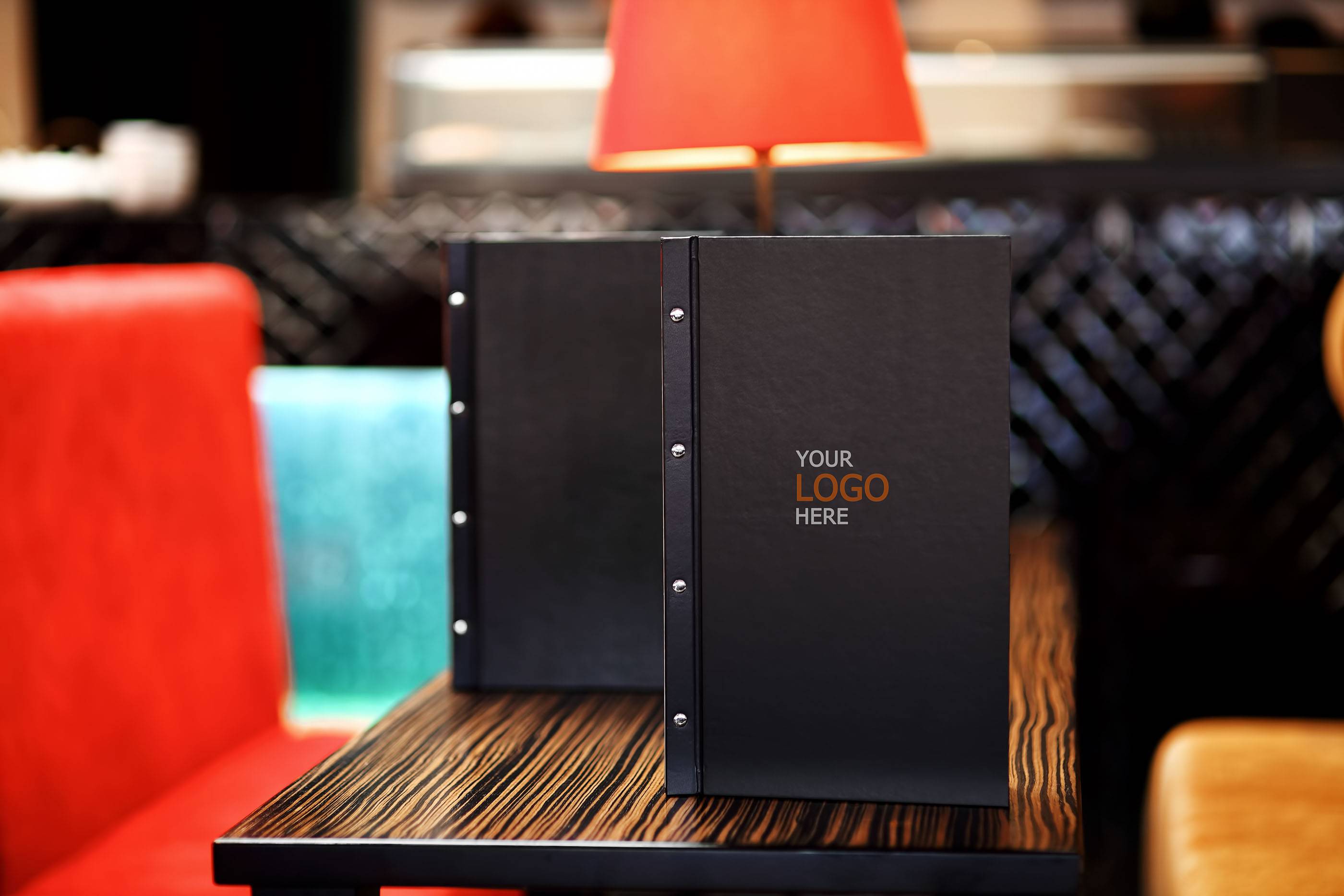 Стол в суши-ресторане: черное меню, деревянные подносы, свежие роллы, васаби, имбирь и палочки. Японская кухня и подача блюд. Современный интерьер ресторана.