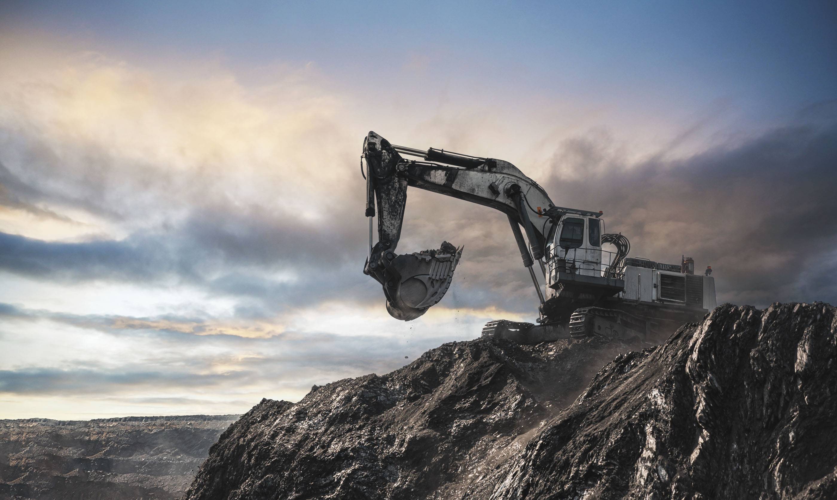 Большой карьерный самосвал и экскаватор. Крупная техника на угольном разрезе. Погрузка угля в кузов. Добыча полезных ископаемых. Транспортировка угля из разреза.