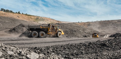 Большой карьерный самосвал. Загрузка породы. Погрузка угля в кузов. Карьерная техника и экскаватор для транспортировки угля из разреза.