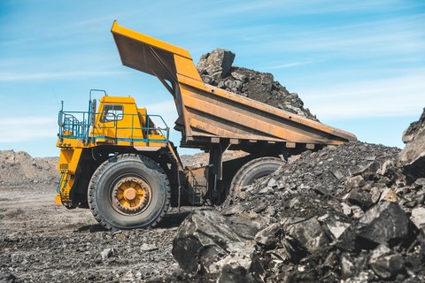Большой карьерный самосвал. Загрузка породы в самосвал. Погрузка угля в кузов грузовика. Карьерная техника для транспортировки угля из разреза. Добыча полезных ископаемых