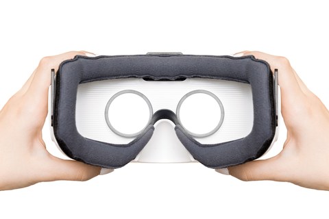 Счастливая женщина использует VR-гарнитуру виртуальной реальности дома, активно жестикулируя