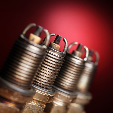 старые свечи зажигания на красном фоне