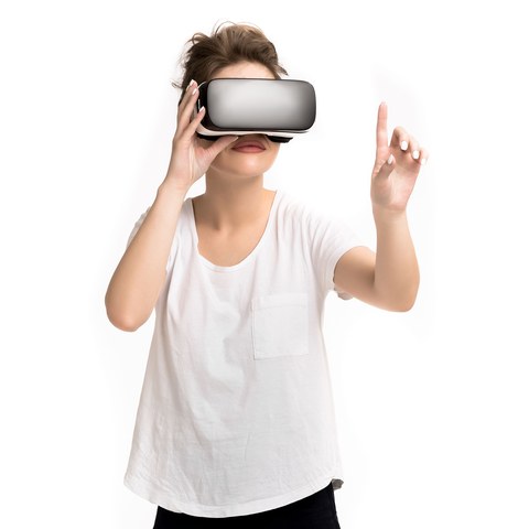 Счастливая женщина использует VR-гарнитуру виртуальной реальности дома, активно жестикулируя