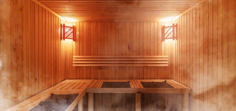 Интерьер финской сауны, классическая парная. Русская баня. Отдых в горячей сауне. Деревянная отделка, скамейки и аксессуары для сауны, спа-комплекс.