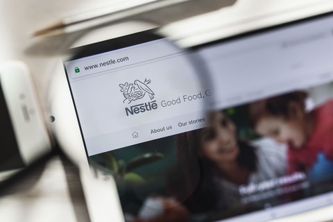 Веве, Во, Швейцария — 16 марта 2019 г.: главная страница сайта Nestle, S.A. под лупой. Концепт Nestle: логотип на экране планшета и смартфона