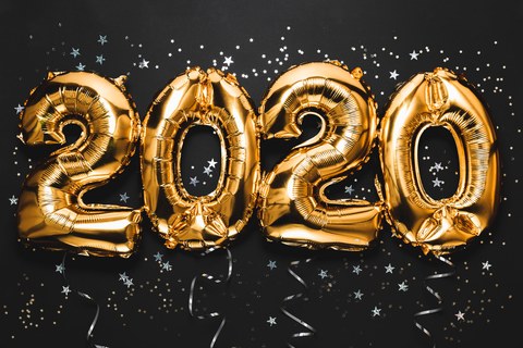 Празднование Нового 2020 года. Яркие золотые цифры, новогодние шары с блестками на темном фоне. Рождественское и новогоднее торжество. Фольгированные цифры 2020 и конфетти